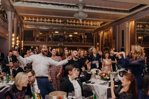 Guests on their feet, singing and toasting, at the Golden Unicorn Awards 2018 gala in the Sheraton Grand Park Lane ballroom